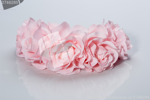 Image of tiara of artificial  roses on a light background