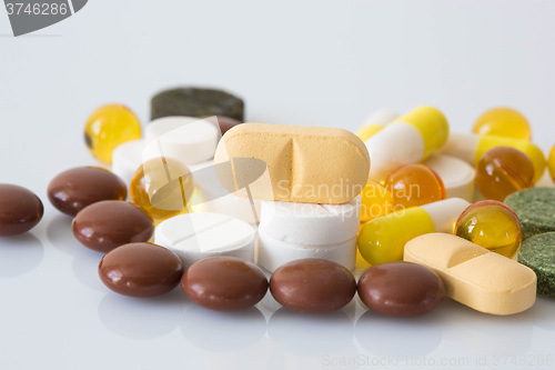 Image of Pile of various colorful pills isolated on white