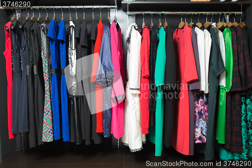 Image of women\'s dresses on hangers in a retail shop