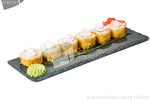 Image of set of sushi on black slate substrate, isolated white background