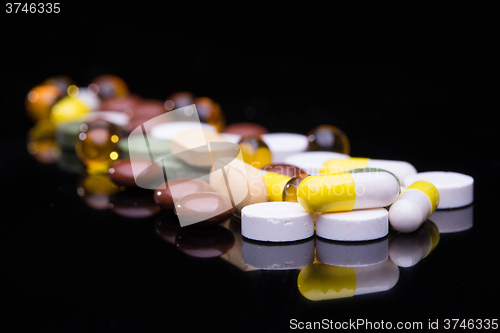 Image of Pile of various colorful pills isolated on black