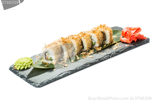 Image of set of sushi on black slate substrate, isolated white background