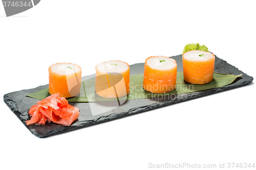 Image of set of sushi on black slate substrate, isolated white background