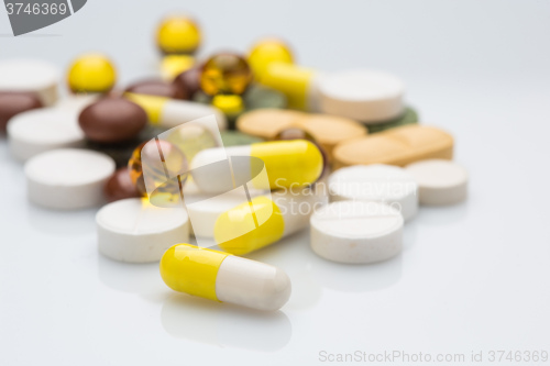 Image of Pile of various colorful pills isolated on white