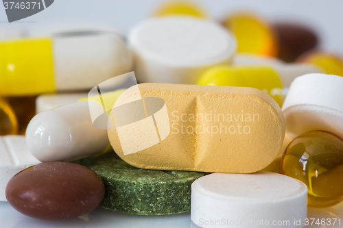 Image of Pile of various colorful pills isolated on white