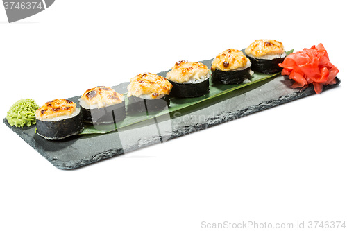 Image of set of sushi on black slate substrate, isolated white background