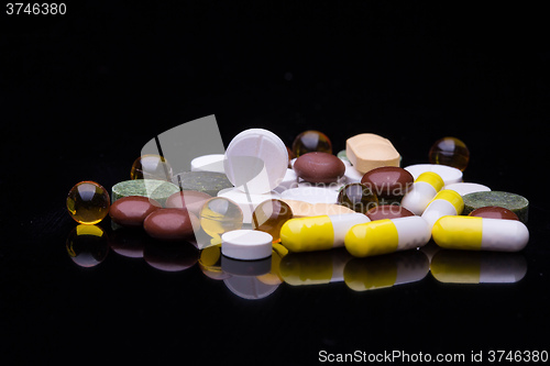 Image of Pile of various colorful pills isolated on black