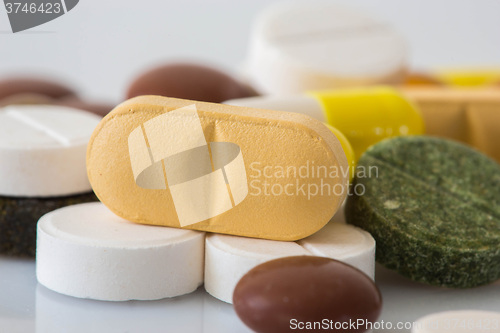 Image of Pile of various colorful pills isolated on white