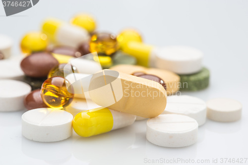 Image of Pile of various colorful pills isolated on white