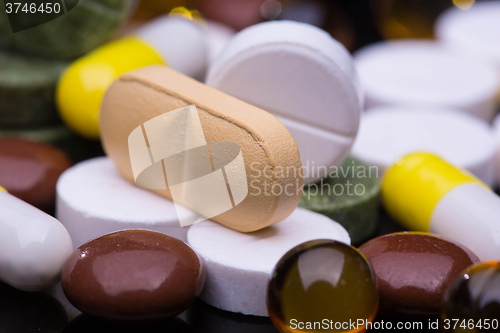 Image of Pile of various colorful pills isolated on black