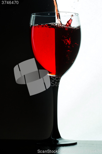 Image of Red wine pouring. white on black background