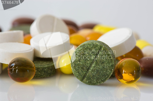 Image of Pile of various colorful pills isolated on white