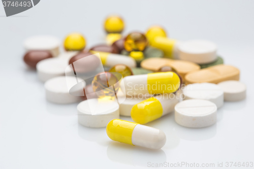 Image of Pile of various colorful pills isolated on white