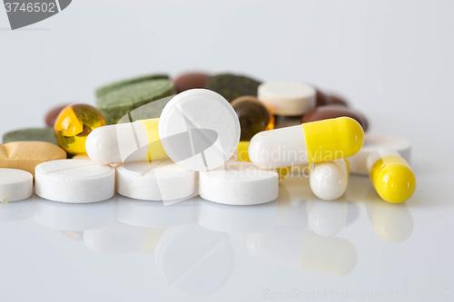 Image of Pile of various colorful pills isolated on white