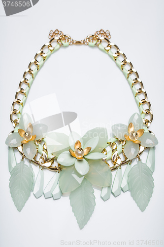 Image of plastic necklace. beige flower
