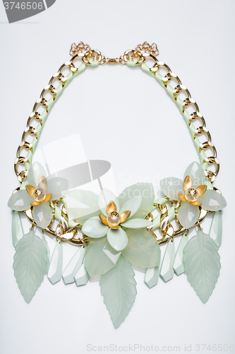 Image of plastic necklace. beige flower