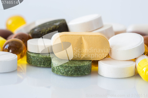 Image of Pile of various colorful pills isolated on white