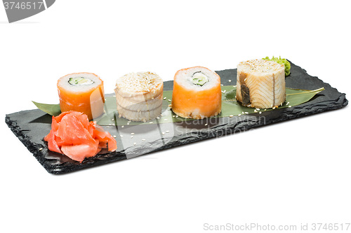 Image of set of sushi on black slate substrate, isolated white background