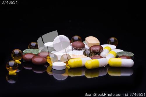 Image of Pile of various colorful pills isolated on black