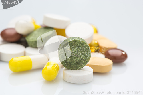 Image of Pile of various colorful pills isolated on white