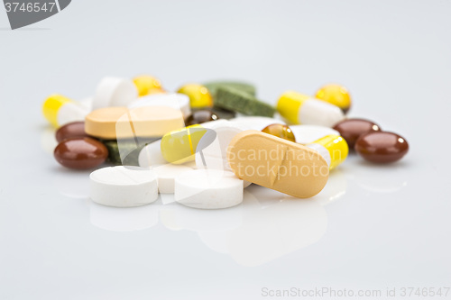 Image of Pile of various colorful pills isolated on white