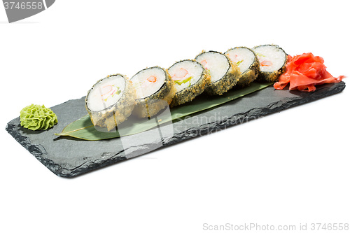 Image of set of sushi on black slate substrate, isolated white background