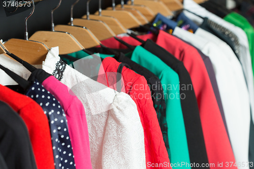 Image of women\'s dresses on hangers in a retail shop