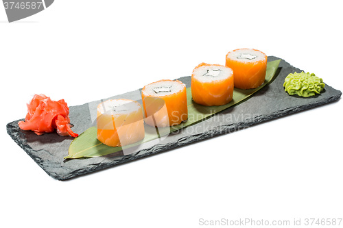 Image of set of sushi on black slate substrate, isolated white background