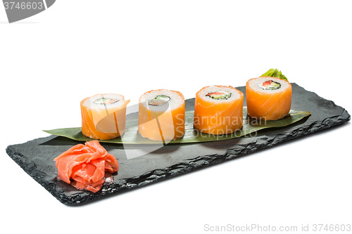 Image of set of sushi on black slate substrate, isolated white background