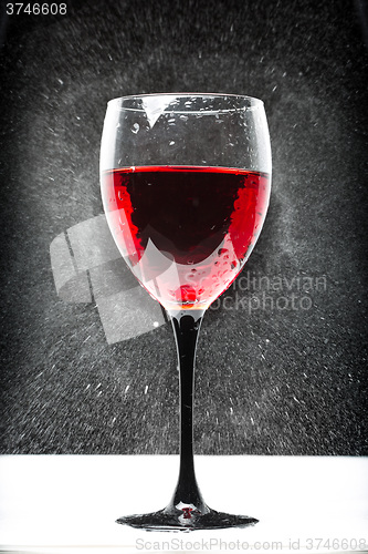 Image of glass with red wine. splashing water
