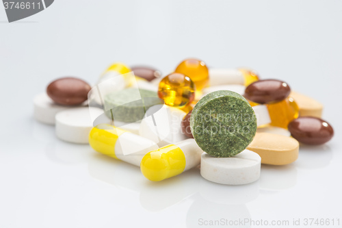 Image of Pile of various colorful pills isolated on white