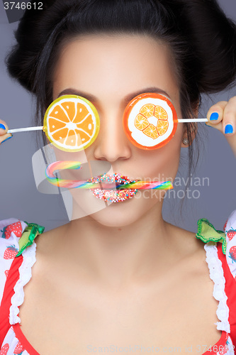 Image of Beautiful pin-up girl holding sweet lollipop
