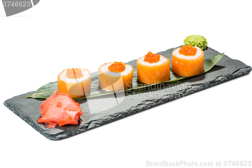 Image of set of sushi on black slate substrate, isolated white background