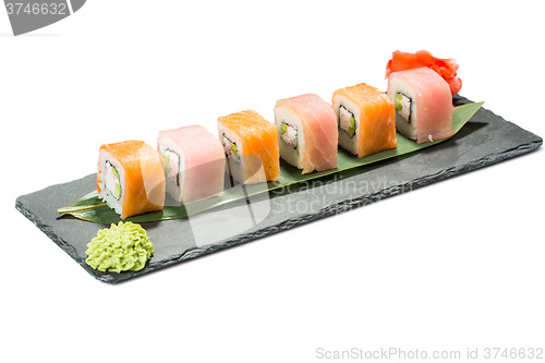 Image of set of sushi on black slate substrate, isolated white background