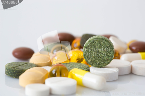 Image of Pile of various colorful pills isolated on white