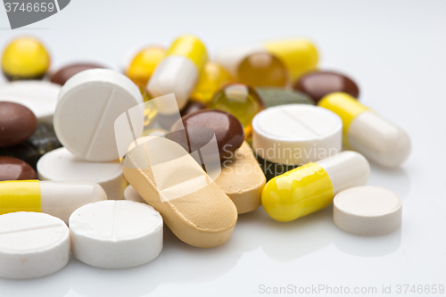 Image of Pile of various colorful pills isolated on white