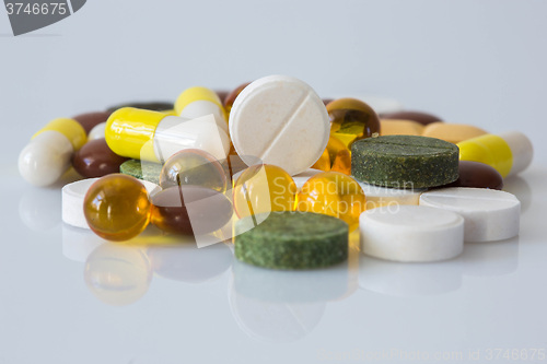 Image of Pile of various colorful pills isolated on white