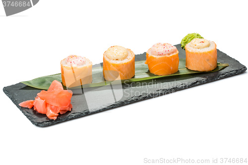 Image of set of sushi on black slate substrate, isolated white background