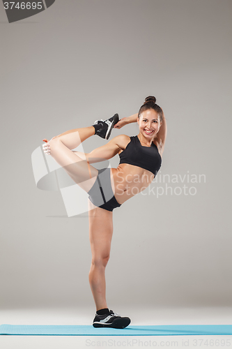 Image of Beautiful sporty girl standing in acrobat pose or yoga asana