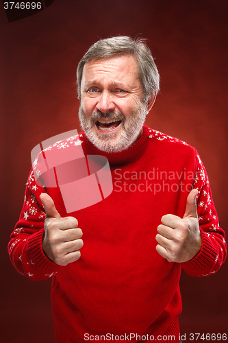 Image of Elderly man showing ok sigh on a red background