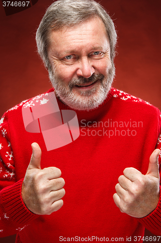 Image of Elderly man showing ok sigh on a red background