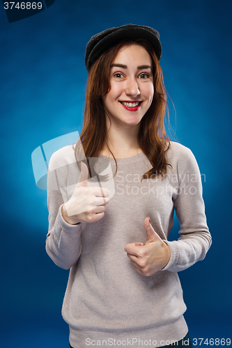 Image of The young girl showing  the ok thumbs up hand sign