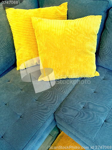 Image of Blue sofa with bright yellow cushions