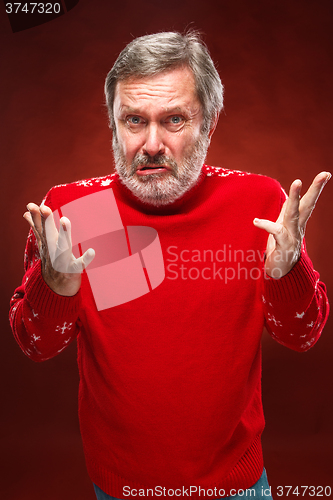 Image of The expressive portrait on red background of a pouter man 