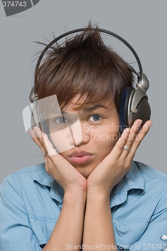 Image of Teen with headphones holding his head