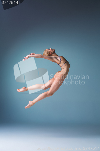 Image of Young beautiful modern style dancer jumping on a studio background