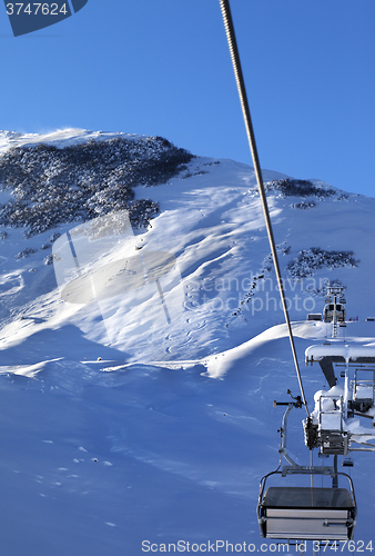 Image of Off-piste slope and chair-lift after snowfall