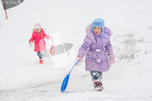 Image of Two girls climb up the icy hill