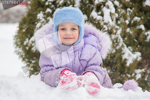 Image of Girl lying in the snow and the snow smiling