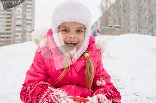 Image of The girl rolled down a hill and looking happily into the frame